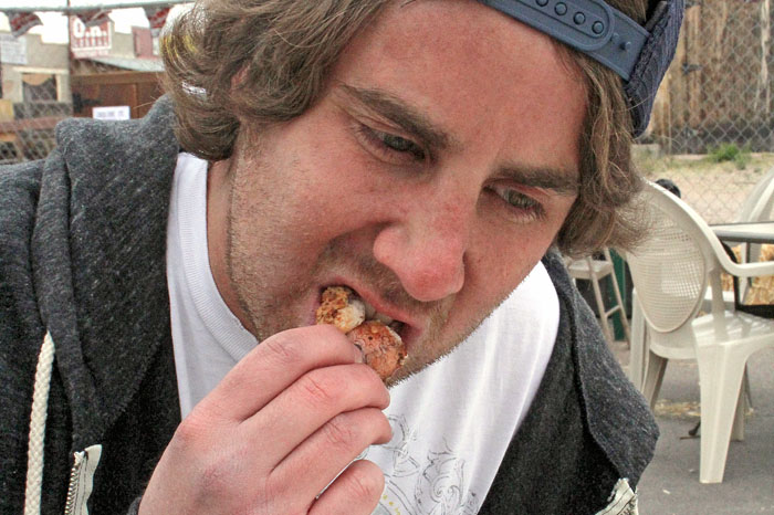 Sam Grossman takes a bite of a Rocky Mountain Oyster at the second annual Beer n' Balls Festival at the Four Deuces Saloon and Grill in Tombston, Ari