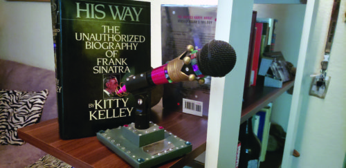 A biography of Frank Sinatra’s life sits next to a bejeweled microphone. Frank Sinatra influences Harvey’s decorating style. Photo by Ella Ford.
