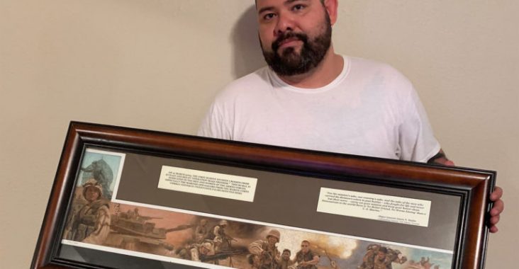 Beto Ureña depicted here 16 years after the invasion of Baghdad holding a plaque remake of the famous photograph of him during the war that was given to him by his unit, 3/7, after the end of his enlistment in the Marines. (Photo by Alberto Quiroz).