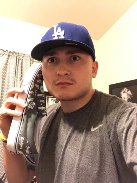 Adriell Alvarado jokingly holds one of his numerous pairs of sneakers (Photo by Ahmaad Lomax).