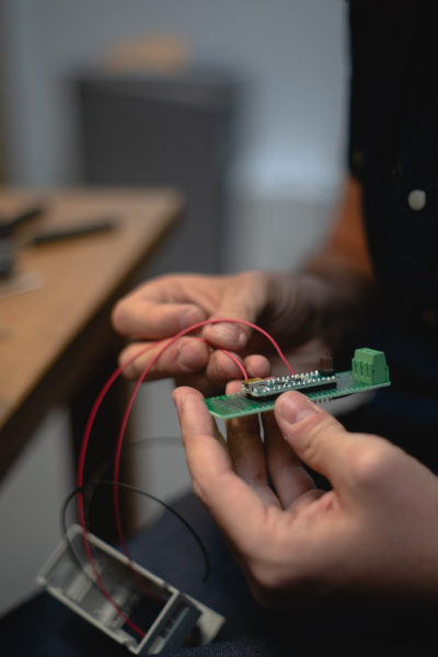 Fuls looks over a new microchip he’s building for the shutter control on a Sky Survey telescope.